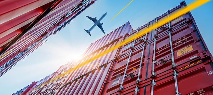 Aircraft flies over shipping container | LGI